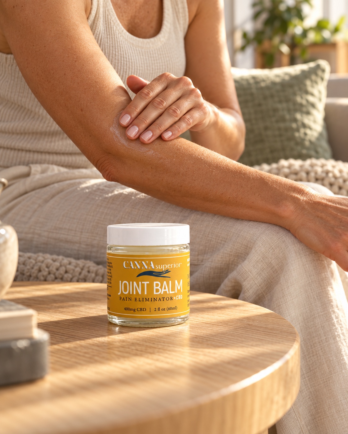 Joint Balm beside a person massaging their forearm at home